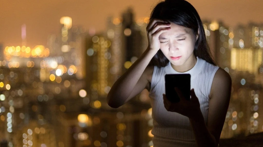 A person using a smartphone while balancing work, communication, and digital wellbeing, highlighting the benefits and drawbacks of mobile phone usage.